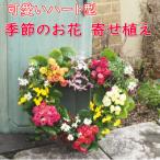 可愛いハート型のリースに季節のお花がたくさん
