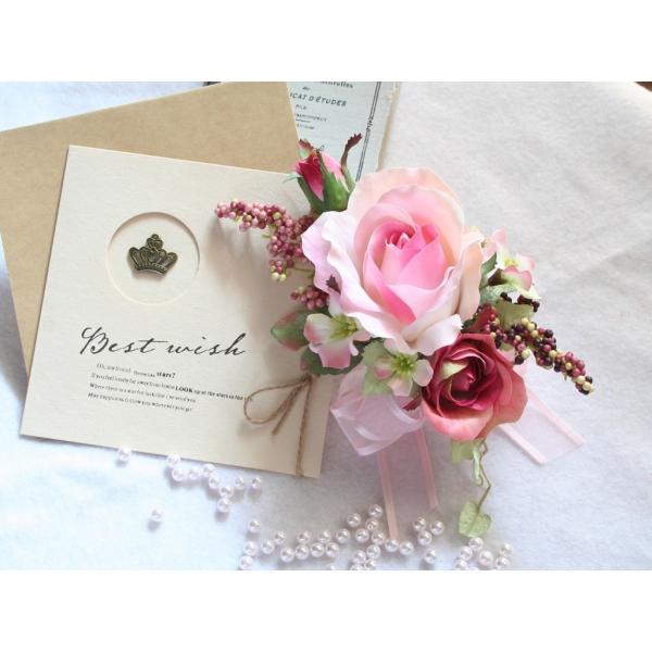 ピンクの流れるようなラインのバラのコサージュ