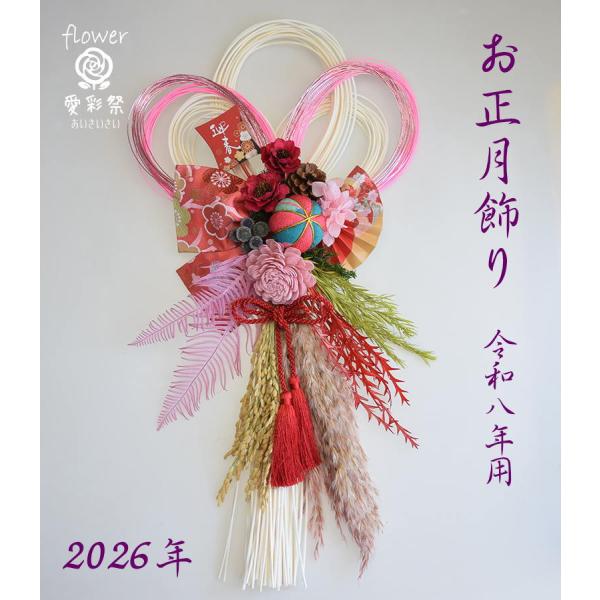 おしゃれなお正月飾り丈夫なラタンベース　ラタン飾り みつ輪 白いベースに赤とピンクのお花で明るい雰囲気に。和の金襴の布　タッセル　水引　凧　の小物使いでおしゃれな仕上がりです。使用花材＝カリナフラワー　ソーラーフラワープリザーブド＝アジサイ...