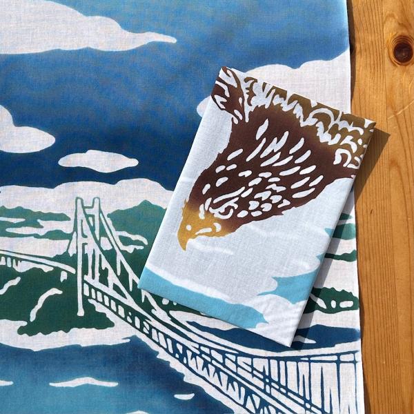 [Release date: March 27, 2020]瀬戸大橋開通30周年を記念して製作した図案です。浮世絵『深川洲崎十万坪（歌川広重）」がモチーフとなっています。大胆に鷲が羽をひろげ、瀬戸大橋の上を舞っている雄大なてぬぐい。空や海の...