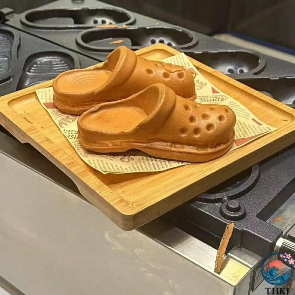 話題の穴あきシューズ焼き機 商用スリッパ型穴あきシューズ エッグワッフル焼き機この画期的な焼き機は、スリッパ型の「穴あきシューズ」を焼くために設計された商用のエッグワッフル焼き機です。見た目が特徴的な「穴あきシューズ」の形状で、話題のスイー...