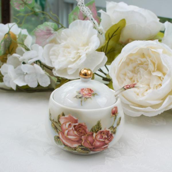 クラシカルで気品のあるゴールドローズ柄のシュガーポット。持ち手に薔薇の柄が入ったスプーン付きです。ティータイムのお供に。■サイズ：約径9.4×H8.3cm■素材：磁器■原産国：日本■電子レンジ・食洗器使用不可製造上、金の塗りムラ、金の変色、...