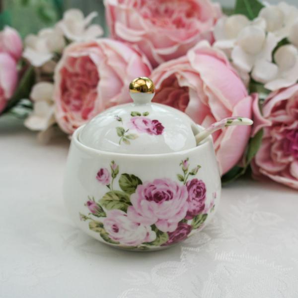 ロマンチックで華やかなアニバーサリーローズ柄のシュガーポット。持ち手に薔薇の柄が入ったスプーン付きです。ティータイムのお供に。■サイズ：約径9.4×H8.3cm■素材：磁器■原産国：日本■電子レンジ・食洗器使用不可製造上、金の塗りムラ、金の...