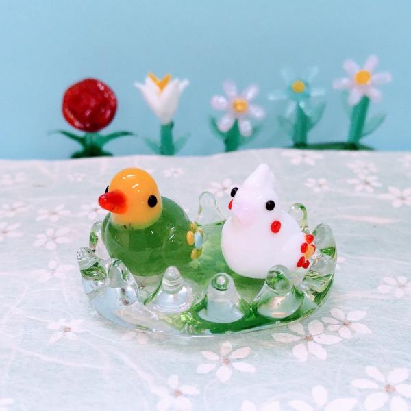 カゴペア花インコ緑/白のガラス細工の置物です。【大きさ】約高さ２０ミリ　　横幅４０ミリ　　　　　奥行２５ミリ＊商品は一つ一つ手造りのため大きさや色合いなどが写真と異なる場合がありますのでご了承をお願い致します。