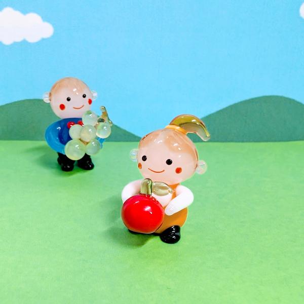 女の子とリンゴのガラス細工の置物です。【大きさ】約高さ２５ミリ　　横幅１５ミリ　　　　　奥行２０ミリ＊商品は一つ一つ手造りのため大きさや色合いなどが写真と異なる場合がありますのでご了承をお願い致します。