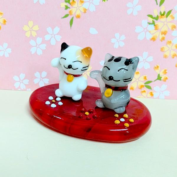 花台招き猫ペア（ミケ/サバトラ）のガラス細工の置物です。【大きさ】約高さ３０ミリ　　横幅５５ミリ　　　　　奥行４０ミリ＊商品は一つ一つ手造りのため大きさや色合いなどが写真と異なる場合がありますのでご了承をお願い致します。