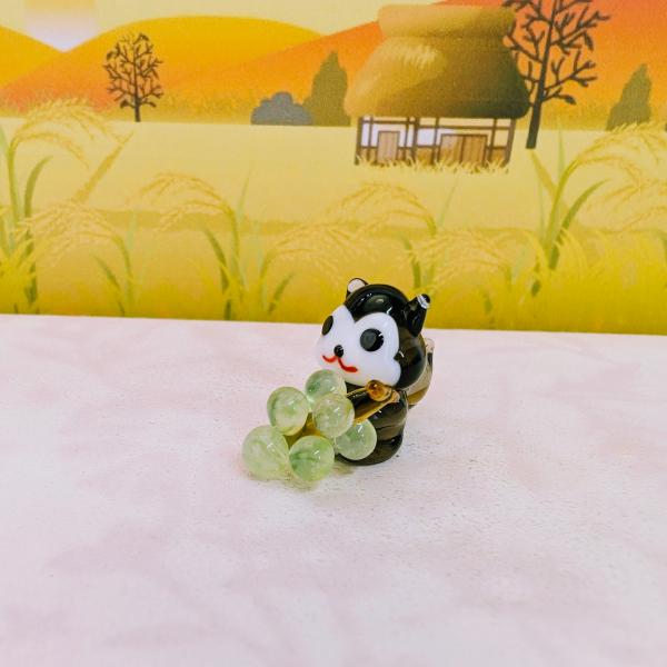 エゾモモンガとシャインマスカットのガラス細工の置物です。【大きさ】約高さ２０ミリ　　横幅１３ミリ　　　　　奥行２５ミリ＊商品は一つ一つ手造りのため大きさや色合いなどが写真と異なる場合がありますのでご了承をお願い致します。