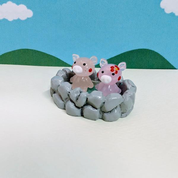 ブタ温泉ペアのガラス細工の置物です。温泉はポリ製です。【大きさ】約高さ２５ミリ　　横幅４５ミリ　　　　　奥行３５ミリ＊商品は一つ一つ手造りのため大きさや色合いなどが写真と異なる場合がありますのでご了承をお願い致します。