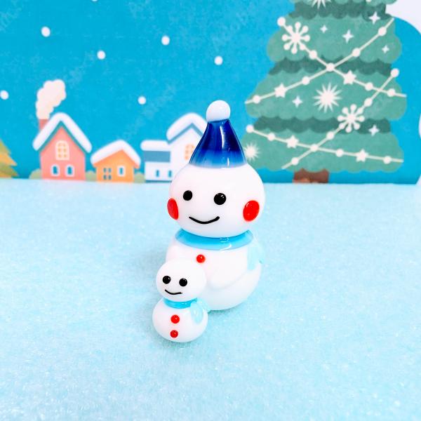 雪だるま親子（青）のガラス細工の置物です。【大きさ】約高さ３５ミリ　　横幅１７ミリ　　　　　奥行２５ミリ＊商品は一つ一つ手造りのため大きさや色合いなどが写真と異なる場合がありますのでご了承をお願い致します。