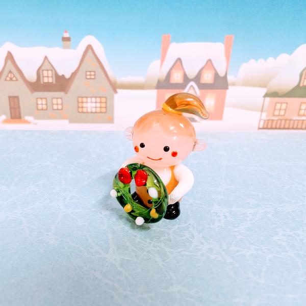 女の子とリースのガラス細工の置物です。【大きさ】約高さ２８ミリ　　横幅１７ミリ　　　　　奥行１８ミリ＊商品は一つ一つ手造りのため大きさや色合いなどが写真と異なる場合がありますのでご了承をお願い致します。