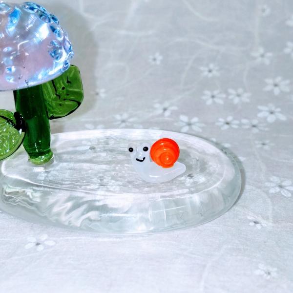 カタツム（ミニ）オレンジのガラス細工の置物です。台は別売りです。【大きさ】約高さ７ミリ　　横幅１０ミリ　　　　　奥行５ミリ＊商品は一つ一つ手造りのため大きさや色合いなどが写真と異なる場合がありますのでご了承をお願い致します。