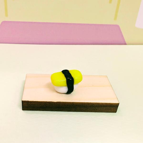 お寿司たまご（S）のガラス細工の置物です。【大きさ】約高さ９ミリ　　横幅１４ミリ　　　　　奥行９ミリ＊商品は一つ一つ手造りのため大きさや色合いなどが写真と異なる場合がありますのでご了承をお願い致します。