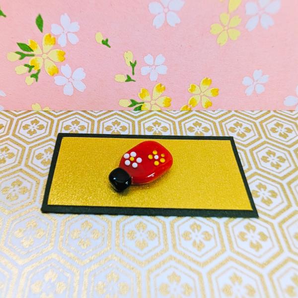 羽子板（ミニ）赤のガラス細工の置物です。【大きさ】約高さ１６ミリ　　横幅１０ミリ　　　　　厚さ4ミリ＊商品は一つ一つ手造りのため大きさや色合いなどが写真と異なる場合がありますのでご了承をお願い致します。