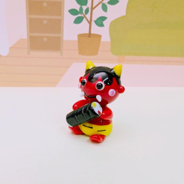 赤鬼と恵方巻のガラス細工の置物です。【大きさ】約高さ２８ミリ　　横幅１８ミリ　　　　　奥行１８ミリ＊商品は一つ一つ手造りのため大きさや色合いなどが写真と異なる場合がありますのでご了承をお願い致します。