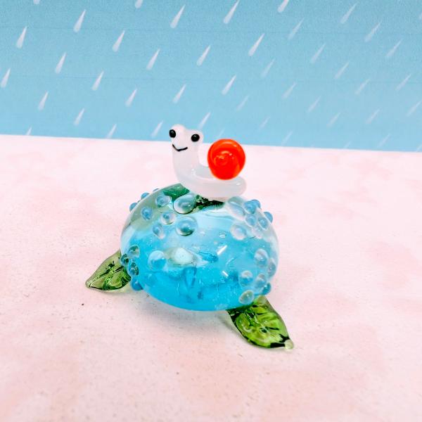 アジサイとカタツムリのガラス細工の置物です。【大きさ】約高さ２３ミリ　　横幅３０ミリ　　　　　奥行３０ミリ＊商品は一つ一つ手造りのため大きさや色合いなどが写真と異なる場合がありますのでご了承をお願い致します。