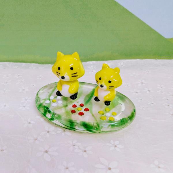 キタキツネペアと花台のガラス細工の置物です。【大きさ】約高さ３０ミリ　　横幅５５ミリ　　　　　奥行３８ミリ＊商品は一つ一つ手造りのため大きさや色合いなどが写真と異なる場合がありますのでご了承をお願い致します。