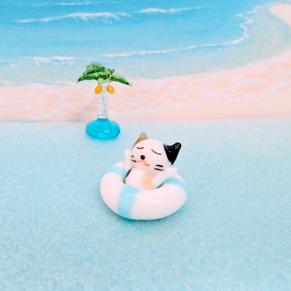 浮き輪とミケネコのガラス細工の置物です。【大きさ】約高さ１８ミリ　　横幅２５ミリ　　　　　奥行２５ミリ＊商品は一つ一つ手造りのため大きさや色合いなどが写真と異なる場合がありますのでご了承をお願い致します。