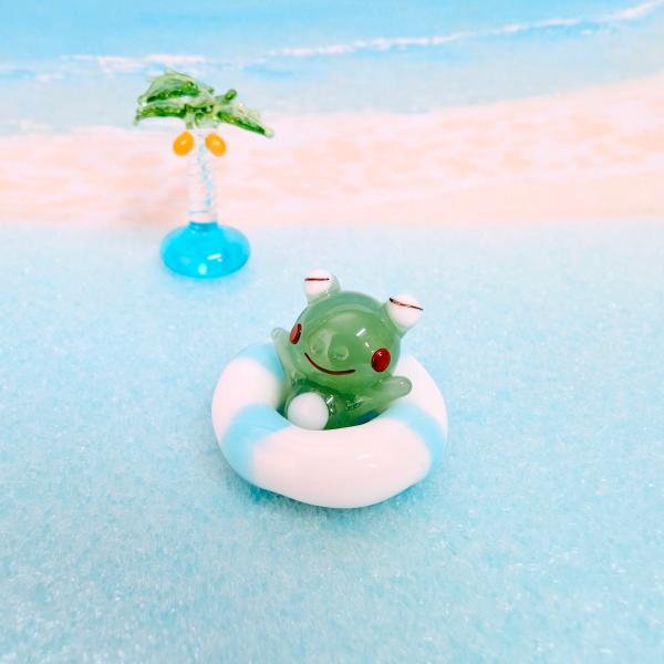 浮き輪とカエルのガラス細工の置物です。【大きさ】約高さ１８ミリ　　横幅２５ミリ　　　　　奥行２５ミリ＊商品は一つ一つ手造りのため大きさや色合いなどが写真と異なる場合がありますのでご了承をお願い致します。