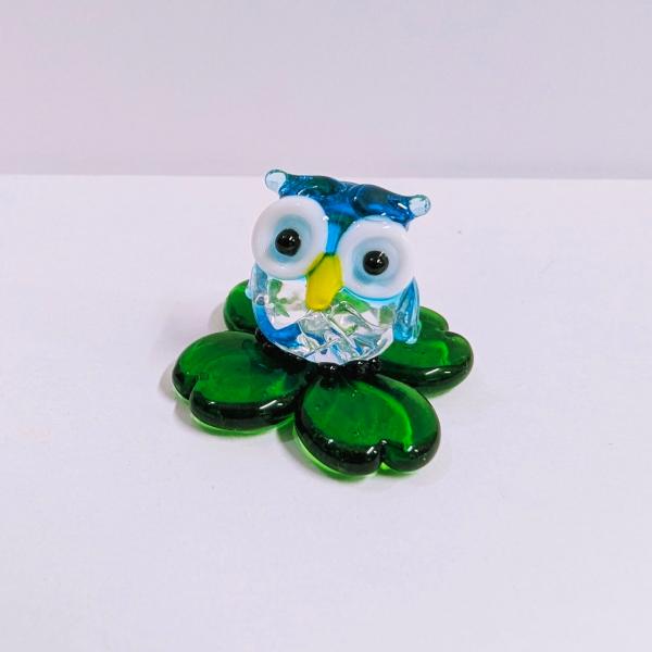ふくろうと四つ葉（青）のガラス細工の置物です。【大きさ】約高さ２０ミリ　　横幅２５ミリ　　　　　奥行３３ミリ＊商品は一つ一つ手造りのため大きさや色合いなどが写真と異なる場合がありますのでご了承をお願い致します。