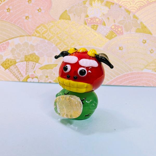 獅子舞いと小判（金箔入）のガラス細工の置物です。【大きさ】約高さ２５ミリ　　横幅２０ミリ　　　　　奥行２０ミリ＊商品は一つ一つ手造りのため大きさや色合いなどが写真と異なる場合がありますのでご了承をお願い致します。