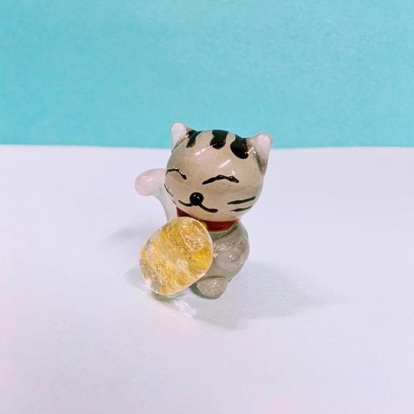 招き猫（サバトラ）と小判（金箔入）のガラス細工の置物です。【大きさ】約高さ２３ミリ　　横幅１８ミリ　　　　　奥行１８ミリ＊商品は一つ一つ手造りのため大きさや色合いなどが写真と異なる場合がありますのでご了承をお願い致します。