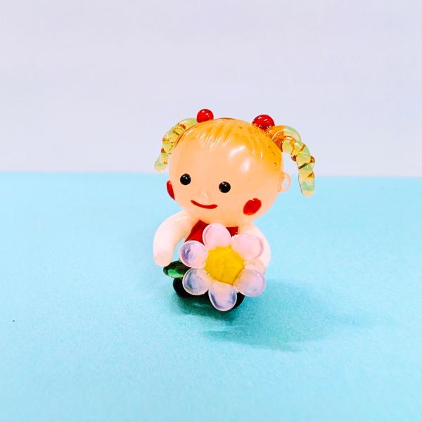 女の子とコスモスのガラス細工の置物です。【大きさ】約高さ２５ミリ　　横幅２５ミリ　　　　　奥行１８ミリ＊商品は一つ一つ手造りのため大きさや色合いなどが写真と異なる場合がありますのでご了承をお願い致します。