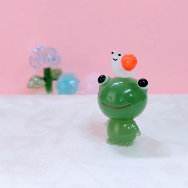 カエルとカタツムリのガラス細工の置物です。【大きさ】約高さ３０ミリ　　横幅１５ミリ　　　　　奥行１５ミリ＊商品は一つ一つ手造りのため大きさや色合いなどが写真と異なる場合がありますのでご了承をお願い致します。