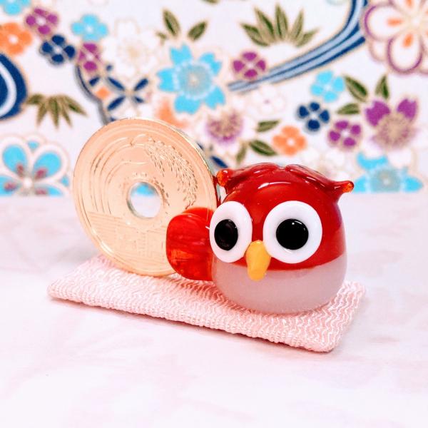 ご縁ふくろう赤のガラス細工の置物です。＊5円は本物を磨いてます。布はちりめん素材です。【大きさ】約高さ２２ミリ　　横幅４０ミリ　　　　　奥行２０ミリ　　　布台４０ｘ２０ミリ＊商品は一つ一つ手造りのため大きさや色合いが写真と異なる場合がありま...