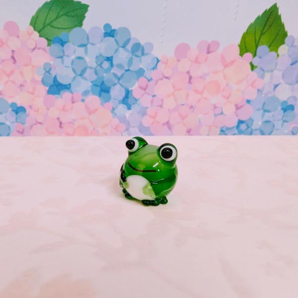 丸カエル（M)のガラス細工の置物です。【大きさ】約高さ１５ミリ　　横幅１５ミリ　　　　　奥行１５ミリ＊商品は一つ一つ手造りのため大きさや色合いなどが写真と異なる場合がありますのでご了承をお願い致します。