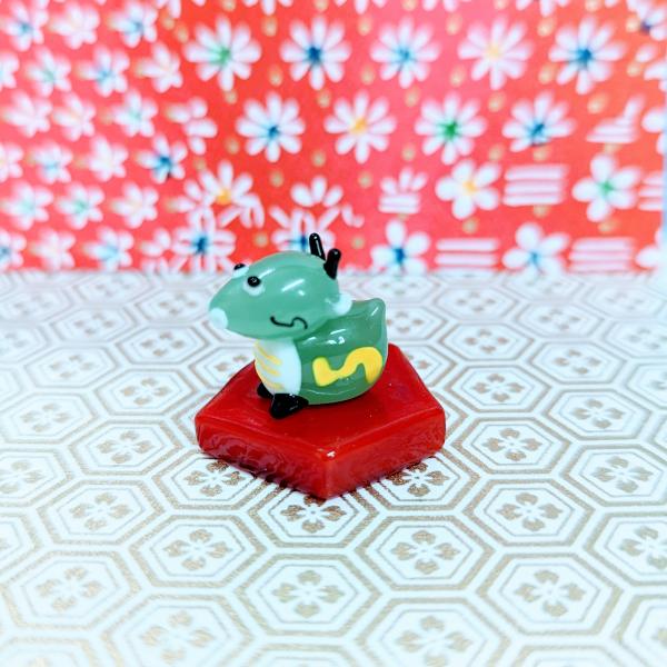 風水ドラゴン（五角台付）のガラス細工の置物です。【大きさ】約高さ２２ミリ　　横幅２５ミリ　　　　　奥行２５ミリ＊商品は一つ一つ手造りのため大きさや色合いなどが写真と異なる場合がありますのでご了承をお願い致します。