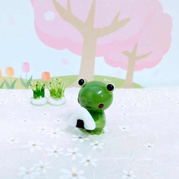 カエルとおにぎりのガラス細工の置物です。【大きさ】約高さ２５ミリ　　横幅１７ミリ　　　　　奥行２０ミリ＊商品は一つ一つ手造りのため大きさや色合いなどが写真と異なる場合がありますのでご了承をお願い致します。