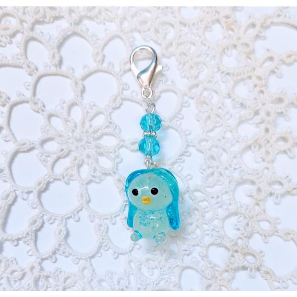 マスクチャームアマビエ青のガラス細工です。金具はホワイトシルバーとガラスのカットビーズを使用しています。暗いところで光ります。【大きさ】約縦全長５０ミリ　　カニ爪約１０ミリ＊商品は一つ一つ手造りのため大きさや色合いが写真と異なる場合がありま...