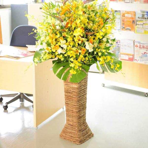 籐かごを思わせるスクエアタイプのスタンド花！（ハイスタンド）お花は色鮮やかに、ボリューム感を出しお仕立てし、季節に合わせて旬なお花をお届けしております。開店祝いや開業祝いに利用されるスタンドタイプのお花ですが、他のスタンド花と違い籐を編み込...