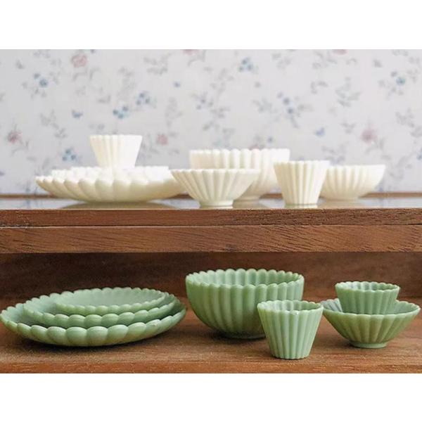 優雅なスカラップ模様を施した、ミニチュアサイズの食器セット（8点）です。本物そっくりの質感とディテールで、和食・洋食どちらのディスプレイにも使えるデザイン。大小様々な形状のプレートやカップで構成されており、重ねたり並べたりすることで、ミニチ...