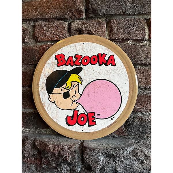 アメリカ人なら誰もが知ってるフーセンガム バズーカ バブルガム！そのメッチャ昔のオリジナル看板を完全復刻させたヴィンテージ好きにはたまらない1枚がこちら！バズーカの宣伝キャラクターで片目に眼帯をした金髪の少年「バズーカ・ジョー」が登場してる...