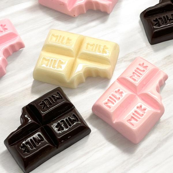 ご覧になって頂きありがとうございます。板チョコがモチーフのアクリルパーツです。少し欠けている感じが可愛くておススメです。ヘアアクセサリーや、小物、インテリアなどいろいろな用途でご使用ください。【内容数】同カラー3個【サイズ】約2cm×2.5...