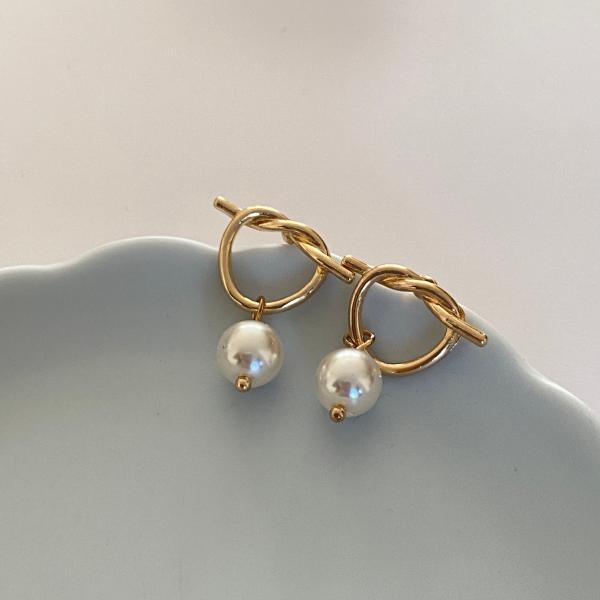 結び目デザインのポストと揺れるパールモチーフが可愛いピアス。※ 撮影時のライティング、PCやスマートフォンなどお使いのモニター環境により、商品画像の色味や質感が実際の商品と異なって見える場合がございます。