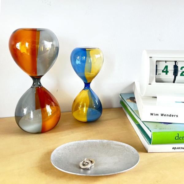 バイカラーの色ガラスが美しい　HIGHTIDE/ハイタイド　ガラス製砂時計Mです。砂の色は白、計測時間は10分です。職人による手しごとのため個体差があり、ガラスの表情もそれぞれ異なります。見る角度や向きによって色の重なりも楽しめる逸品です。...