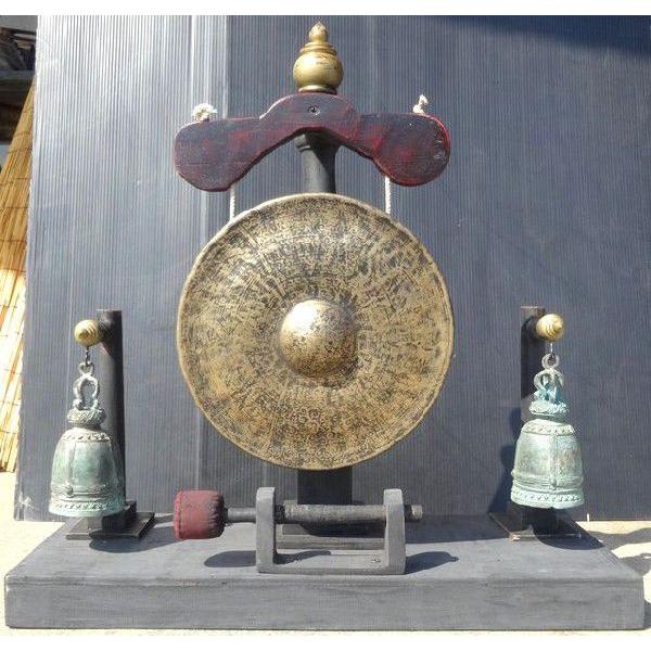 タイで作られている土台付きの銅製ゴングとベルです。ハンドメイドの木製台に上質のゴングと２つの釣鐘が付いています。デザイン性抜群の土台付きですので、インテリアとしての存在感が高い一品です。音程は「Ｃ＃」です。サイズ−全高：約５９ｃｍ、全幅：約...