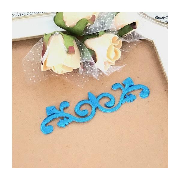 アイロン接着できるターコイズブルーの刺繍モチーフです。新体操、バレエ、レオタード、バトントワリング 、ドレス、ステージ衣装などに飾り付けるモチーフです。手縫いとアイロンで貼り付けることもできます。サイズ：H2.8cm W10cmカラー：ター...