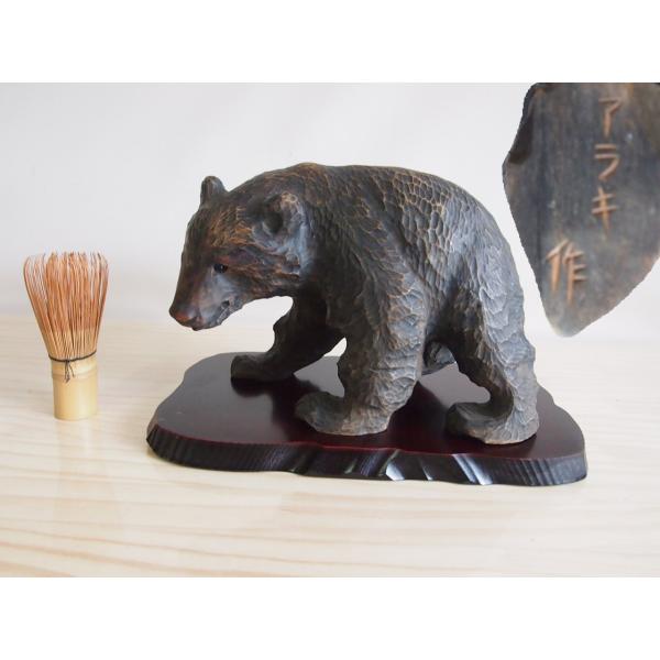 昭和時代に活躍した彫刻家アラキ作(荒木清峰)ガラス目木彫り熊25ｃｍです。卓越したノミさばきで鑿跡の残る荒々しい彫ながら造形を良く捉えていて愛くるしさ溢れた光沢ある小さなガラス目が生き生きと輝いています★木製の敷き板も付属します。年期は感じ...