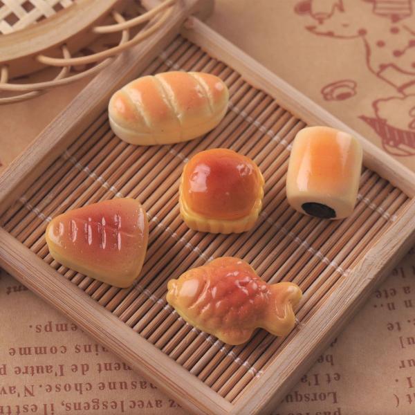 小さな菓子パン、5個セットです。材料：樹脂セット内容：各1個・鯛焼き              約21  x  12  x  10mm・あんパン           約13  x  14  x  10mm・カップケーキ     約17  x...