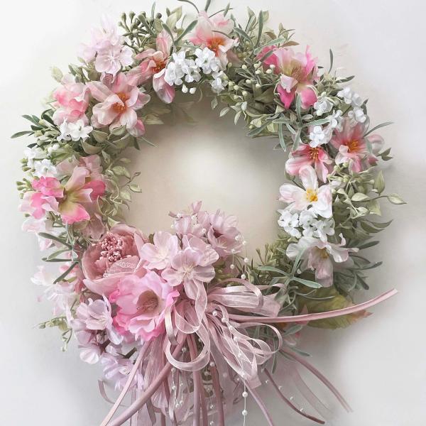 春色新作・・・春の演出に桜とリボンでアレンジした春色のハンドメイド手作りフラワーリースです。明るくエレガントで繊細な色合いです。優しい桜色と少しビビットなピンクでアレンジ。添え花のラナンキュラスとオーガンジーリボンはフォーマルなシーンの演出...