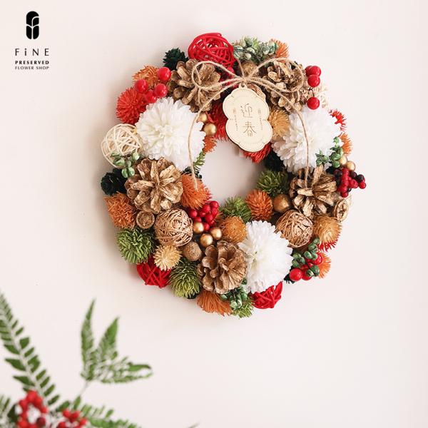 カジュアルな迎春リース丸みのあるパーツをふんだんに使用したおめでたいリースsize：サイズ:径25.5×厚み6.5cm材質：ラタン、ポリプロピレン、発泡スチロール、木こちらのリースは中国より輸入した既製品です。全てメーカーにて検品したものを...