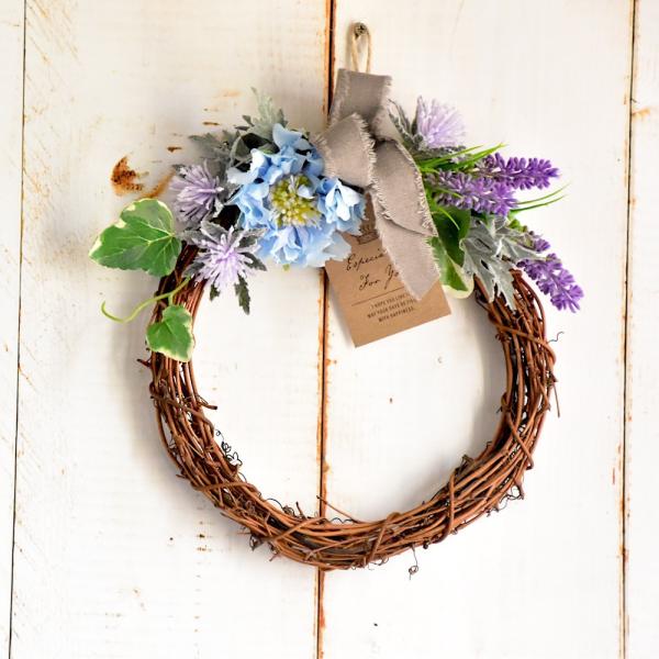 こちらの商品は全国送料無料商品です。＊新デザインになりました。爽やかな色合いの小ぶりなフラワーリースです。清涼感漂う濃淡のグラデーション。アクセントのリネンリボンが優しさをいっそう引き立てます。【素材】　　　　　　　アーティフィシャルフラワ...