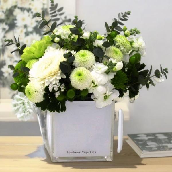 透明感あるアクリルポットに、白とグリーンのお花をぎゅっとアレンジ。爽やかで落ち着いた雰囲気が、テーブルをやさしく彩ります♪ラウンド型で飾りやすく、誕生日・送別・記念日などにぴったり◎・サイズ：約 幅17cm × 高さ17cm・花材は季節によ...