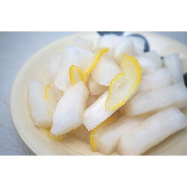 青首大根を短冊切りにし、塩漬けしたものにオリジナルの調味液、柚の皮を加え仕上げました。  ざらめを使っておりますので、あっさりとした甘みに柚子の風味が加わりサラダのような感覚で食べられる一品です。  大根の白に柚の橙色が美しおす。