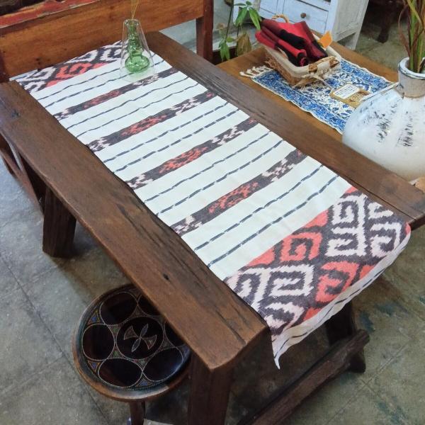 イカットテーブルランナーです。サイズは110×33cmで、伝統的な絣織りを用いた美しいデザインが特徴的です。このプレイスマットは、熟練した職人によって手織りされたもので、独特の風合いが空間に温かみをもたらします。このテーブルランナーは、リビ...