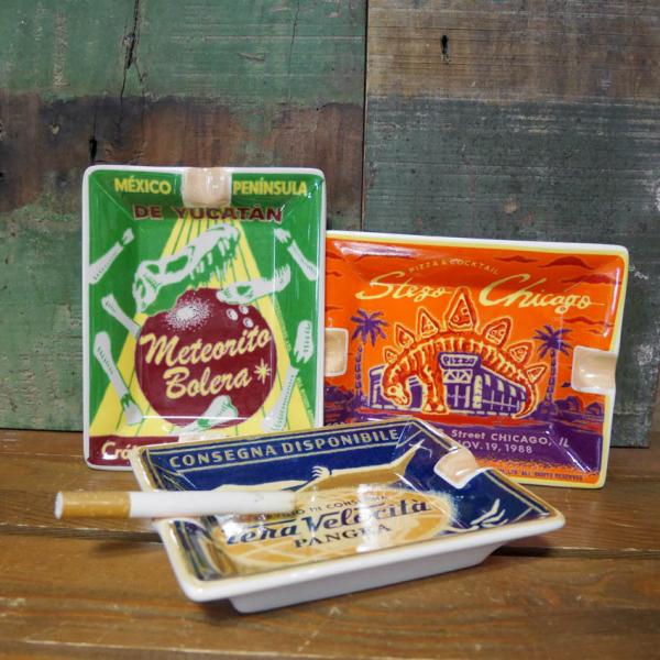 レトロでアーティスティックな柄が古き良き時代を彷彿とさせる卓上灰皿です。レトロなポスターをそのまま小さくしたような個性ある様々な絵柄は、ついコレクションしたくなります。 灰皿以外にも、コイントレイ、アクセサリートレイ、キートレイとしても使い...