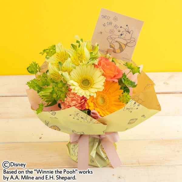 ■お届け 3日後以降でご指定可■注文締切2026/03/28　14:00までみつばちに扮したキュートな「くまのプーさん」がプリントされたオリジナルラッピングペーパーに、はちみつ色の花を集めた華やかなブーケ。バラや、ガーベラを集めて束ねました...